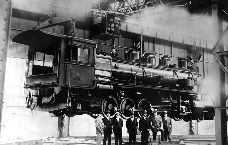 La imagen nos muestra la maquina número 9, levantada para su reparación. Al frente personal y jefatura de la Maestranza de trenes El Colorado de Iquique en 1929.